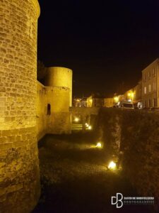Tours du château de nuit éclairé par les lumières des fossés