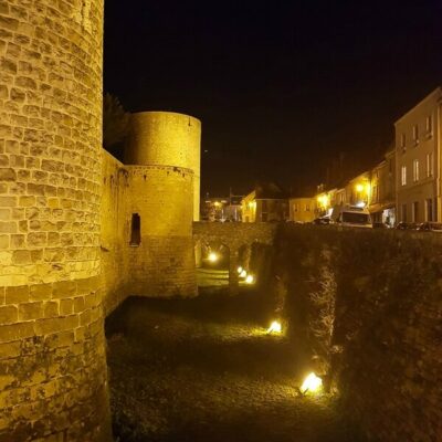Tours du château de nuit éclairé par les lumières des fossés