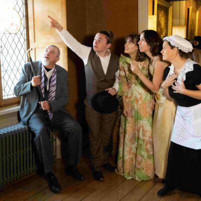 Groupe de comédiens XIXe siècle dans une pièce près d'une fenêtre